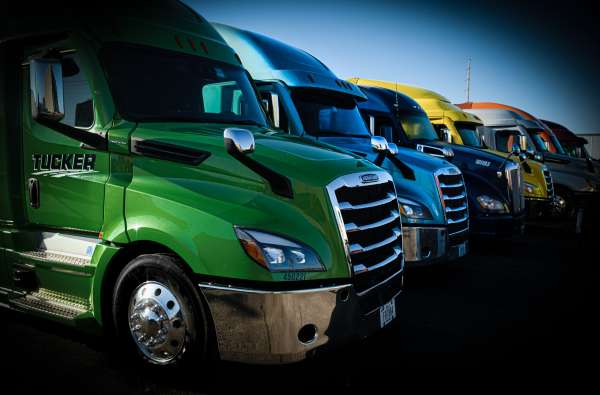 Man smiling at camera in drivers seat of semi