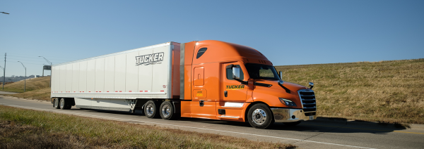 orange Tucker Freight Lines dry van driving on road